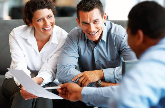 Couple looking over mortgage paperwork with lender photo