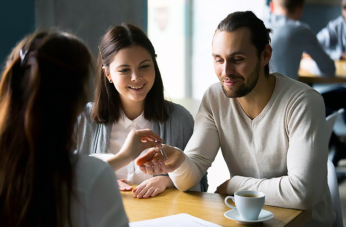 Couple looking over mortgage paperwork with lender photo